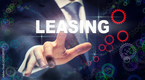 A hand selecting a Leasing business concept on a clear screen with a colorful blurred background.