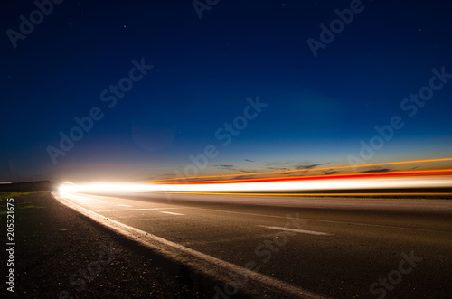 The asphalt road in the countryside with the light passing through it at the speed of cars on long exposure