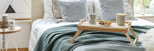 Wooden breakfast tray on bed