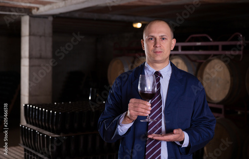 Winemaker inviting to tasting red wine