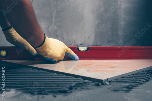 Working tiles lay a large tile on the floor