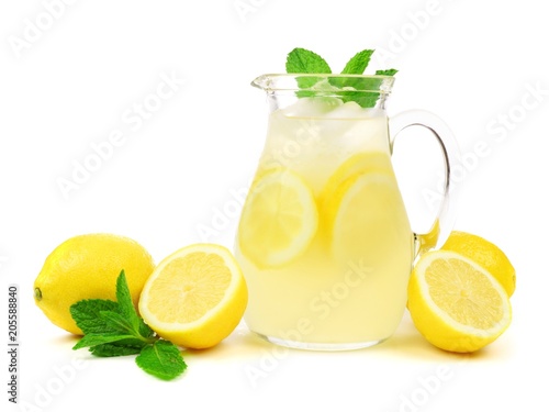 Jug of summer lemonade with lemons and mint isolated on a white background