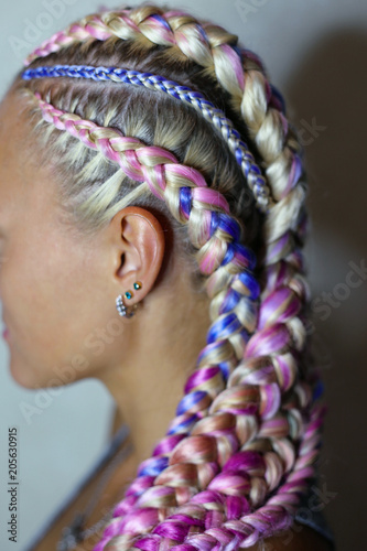 a beautiful hairstyle made of thick and thin braid on the head with a colored kanekalon, hair is woven in material, hair bands