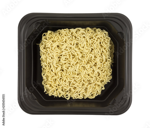 Top view of uncooked plain ramen noodles in a black tray isolated on a white background.