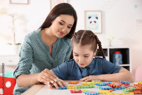 Young woman and little girl with autistic disorder playing at home