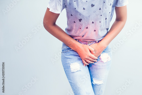 Young sick woman with hands holding pressing her crotch lower abdomen. Medical or gynecological problems, healthcare concept