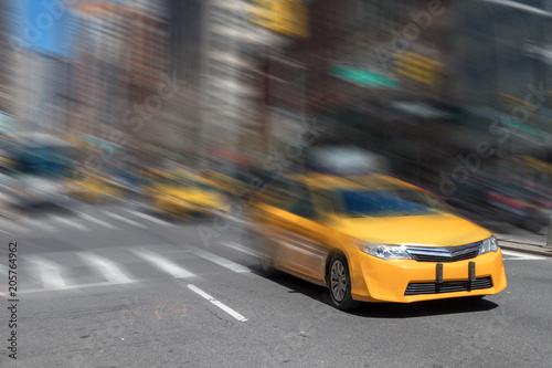 Fast paced yellow taxi cab driving through Manhattan streets in New York City with motion blur background