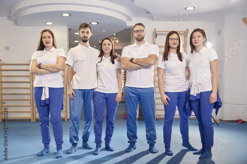 large team, group of physical therapists workers posing, work room indoors.