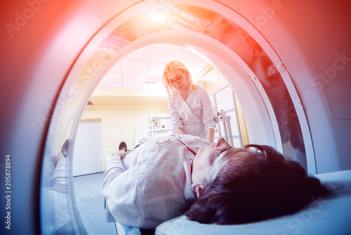 Doctor and patient in the room of computed tomography at hospital.