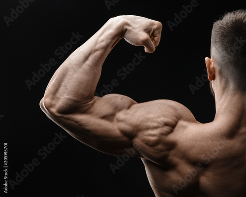 Bodybuilder in good shape against a dark background