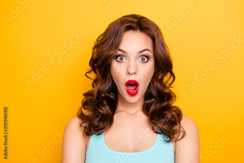 WTF! OMG! Portrait of shocked astonished girl with modern hairdo having wide open mouth eyes looking at camera isolated on yellow background