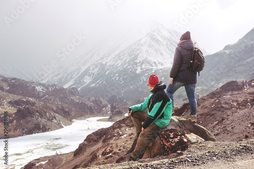 Two tourists at view point against mountains