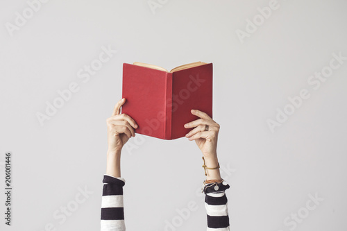 The hand holding book on isolated background