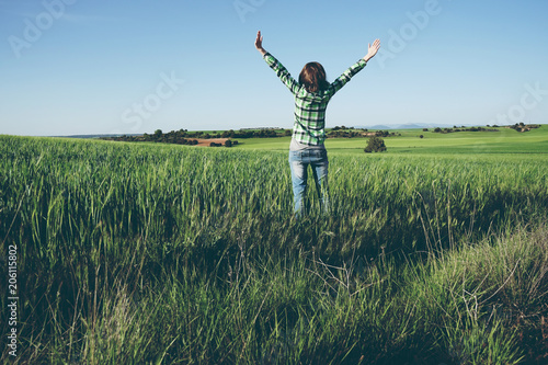 Mujer disfrutando de un día soleado en el campo con los cultivos verdes