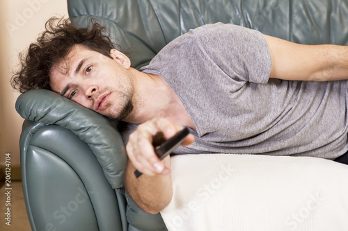 Lazy man with the remote on the couch