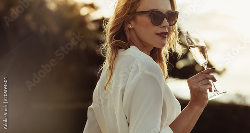 Beautiful young woman drinking wine outdoors