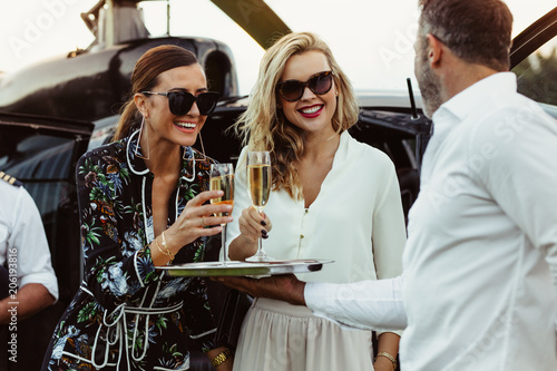 Man greets female friends with wine