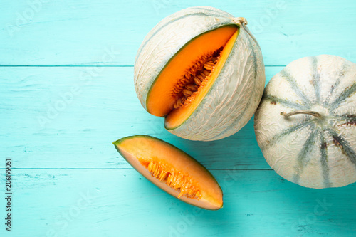 Cantaloupe melons on aquamarine background