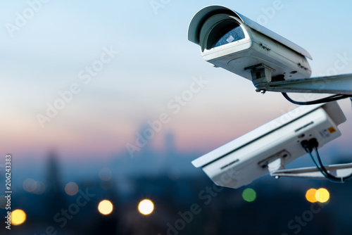 security CCTV camera monitoring system with panoramic view of a city on blurry background