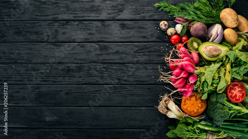 Healthy food. Vegetables and fruits. On a black wooden background. Top view. Copy space.