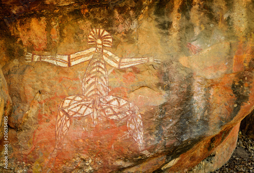 Ancient aboriginal painting of man art on huge rock stone in Kakadu park, northern territory, Australia.