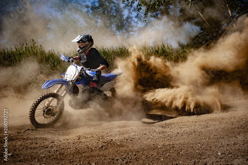 Jeździec Motocross tworzy dużą chmurę pyłu i gruzu