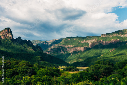 the beauty of nature, mountains covered with lush vegetation, under a sky of white clouds