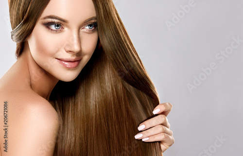 Beautiful brunette girl with long straight smooth hair . A woman with healthy straight hairstyle 