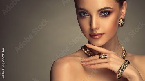 Beautiful girl with set jewelry . Woman in a necklace with a ring, earrings and a bracelet. Beauty and accessories. 