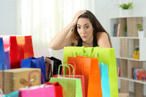 Surprised woman looking at multiple purchases