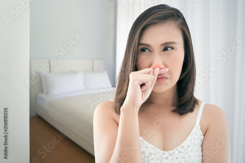 Asian women in white dress feeling unwell and sneeze at bedroom.