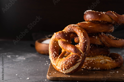 Freshly baked homemade soft pretzel with salt on rustic table. Perfect for Octoberfest. 