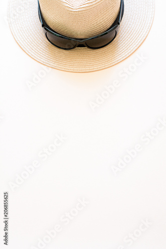 Pink straw hat with sunglasses on paper background. Top view. Flat lay. Summer concept