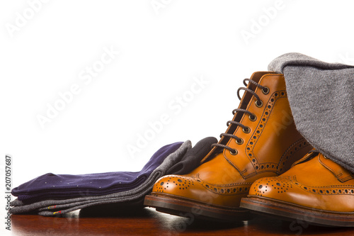 Footwear Compositions Made Up of Mens Fashionable Tanned Brogues Boots, Warm Hat and Batch of Socks Laid Close. Isolated Over White.