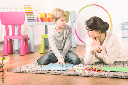 Private tutor and a small boy learning and playing at home. Fun teaching concept