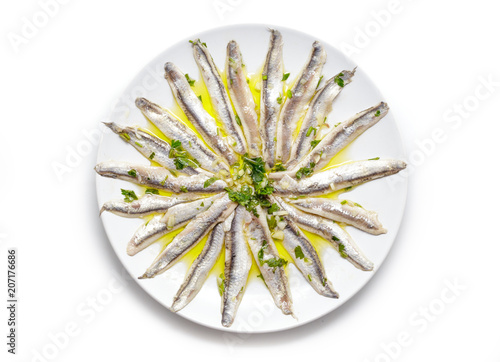 Delicious Marinated anchovies with parsley, olive oil and vinegar isolated on white background.