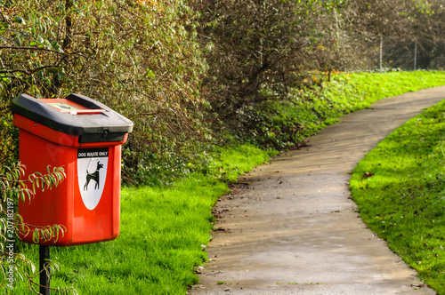 Dog waste bin by a path in a park.