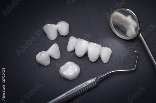 Dental tools and zircon dentures on a dark background - Ceramic veneers - lumineers
