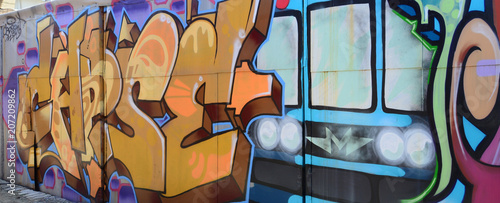Street art. Abstract background image of a full completed graffiti painting in beige and orange tones with the subway train