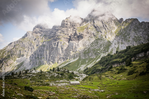 Idyllic alpine landscape of farmhouses, high mountains and unspoiled nature in Switzerland, Glarus