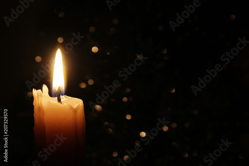 Candles Burning at Night. White Candles Burning in the Dark with focus on single candle in foreground. 