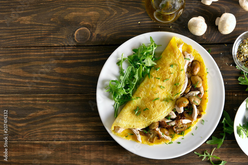  Omelette stuffed with mushrooms, pieces of chicken meat, greens