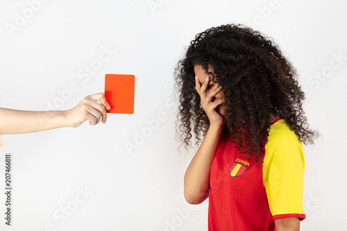 Portrait d'une jeune supportrice de l'équipe d'Espagne prenant un carton rouge