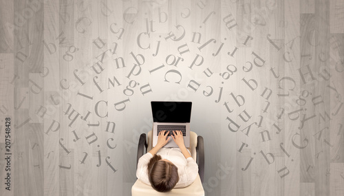 Letters with writer using tablet in a beige chair and an office space 