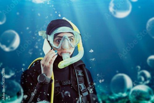 Diver in wetsuit and diving gear, underwater view