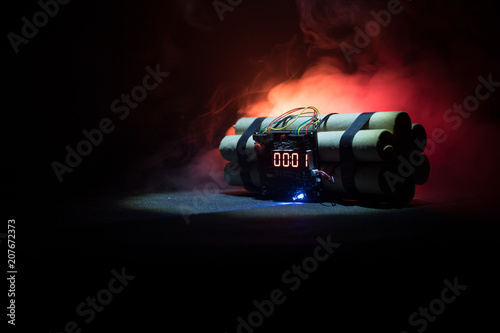 Image of a time bomb against dark background. Timer counting down to detonation illuminated in a shaft light shining through the darkness