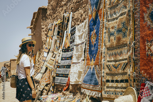 Girl at marketplace staring arabic carpets