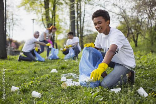 Wildlife volunteer. Energetic male volunteer using garbage bag while collecting litter