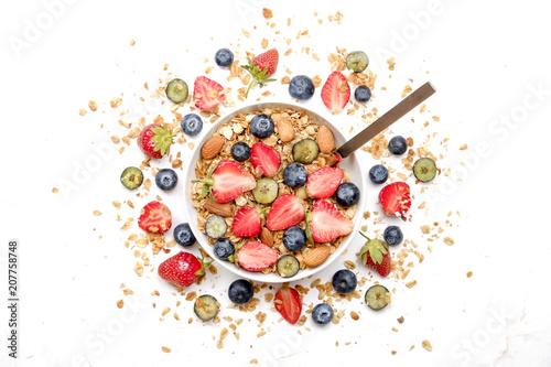 Serving option of granola bowl, mix of nuts, cereals, fruits & berries, greek yogurt, spoon. Healthy vegetarian breakfast, organic strawberry, blueberry, mint, almond. Close up, top view, background.