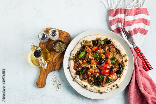 fresh Greek dakos salad on a layer of hummus. light vegan summer nutritious recipe